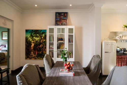 a dining room with a table and chairs and a refrigerator at Dorp Hotel in Cape Town