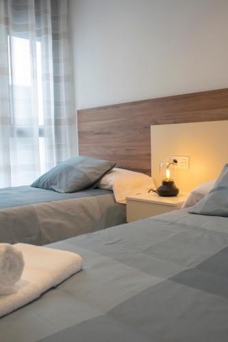 a bedroom with two beds and a lamp on a table at Deluxe Apartament Alcalá la Real in Alcalá la Real