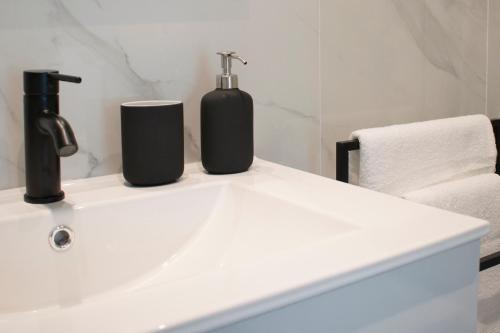 a white sink with two bottles on top of it at Deluxe Apartament Alcalá la Real in Alcalá la Real