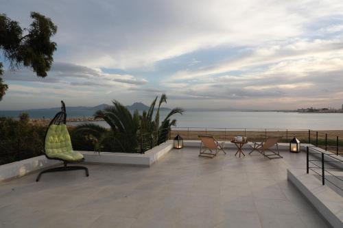 a patio with chairs and a view of the water at La brise de Carthage: Earthly paradise in Carthage