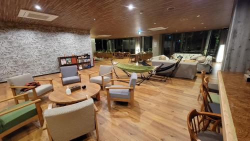 sala de estar con sofá, mesa y sillas en K's House Nikko - Kinugawa Onsen Hostel, en Nikko