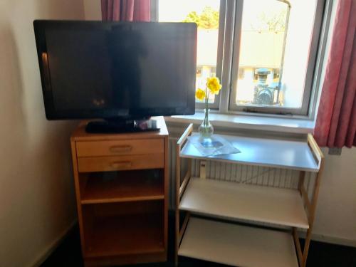 a television on a wooden stand with a tv on it at Hotel Medio Fredericia in Fredericia