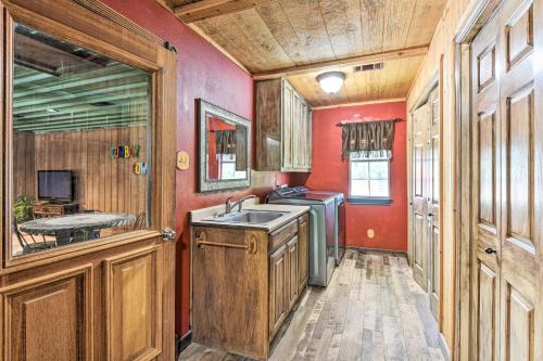 a kitchen with a sink and red walls at Sunset Ranch with Pool and Hot Tub on 29 Acres! in Sunset