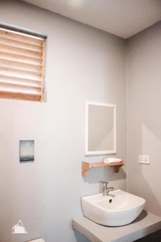 a bathroom with a sink and a mirror at Triangle Palms Siargao in General Luna