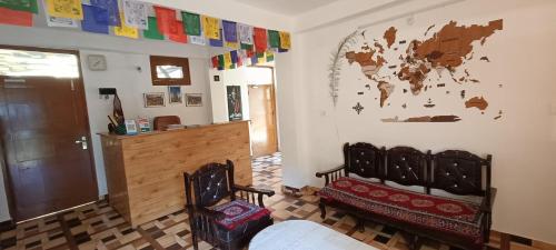 una habitación con 2 sillas y un mapa mundial en la pared en Wanderers Homestay -All mountain facing rooms en Kalpa