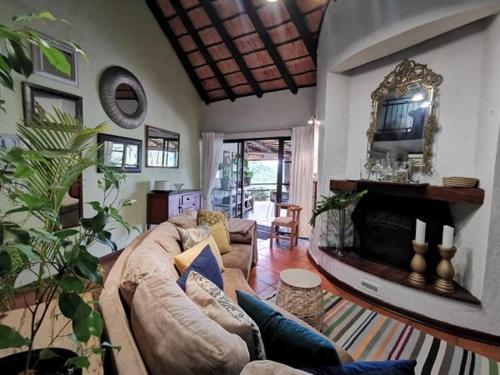 a living room with a couch and a fireplace at The Homestay in Nelspruit