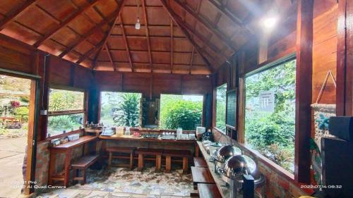 a kitchen with wooden walls and large windows at Pelangi Guest House in Kayu Aro