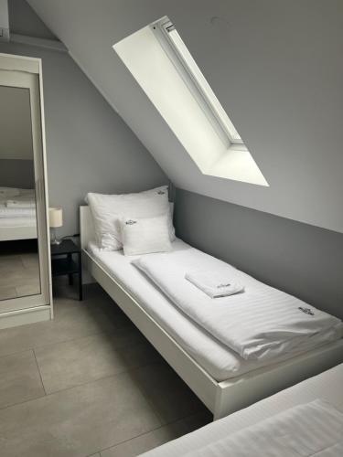 a bed in a room with a skylight and a mirror at MISLENY HOME in Kozármisleny