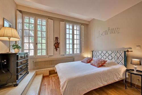 een slaapkamer met een bed met 2 kussens erop bij LA BALANCE DES DOMS - 1 MIN du PALAIS des PAPES - INTRA-MUROS in Avignon