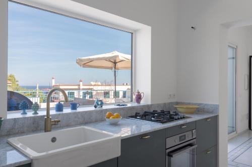 a kitchen with a sink and a large window at Solemar Sicilia - Casa Margherita in Santa Flavia