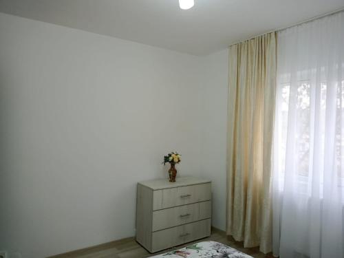 biała komoda w pokoju z oknem w obiekcie Criss Apartament w Suczawie