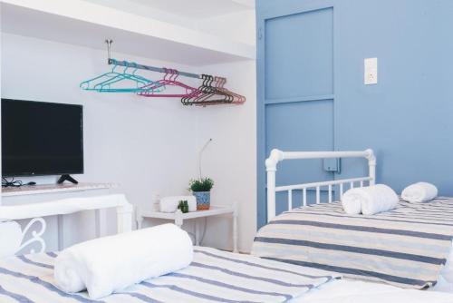 a bedroom with two beds and a flat screen tv at The Mills House in Kallithea