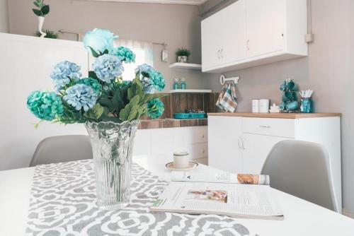 a vase of blue flowers on a table in a kitchen at The Mills House in Kallithea