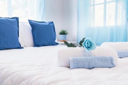 a large white bed with blue pillows in a room at The Mills House in Kallithea