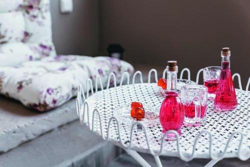 a white table with red bottles and glasses on it at The Mills House in Kallithea