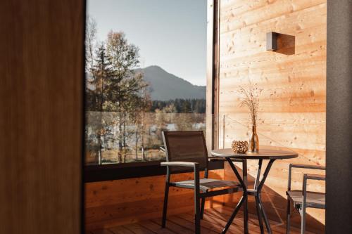 a table and chairs in a room with a window at Alpenhotel Kitzbühel am Schwarzsee - 4 Sterne Superior in Kitzbühel