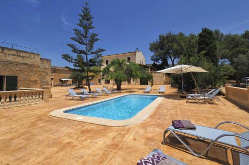 a swimming pool with lounge chairs and an umbrella at Finca Son Sureda Agroturismo in Manacor