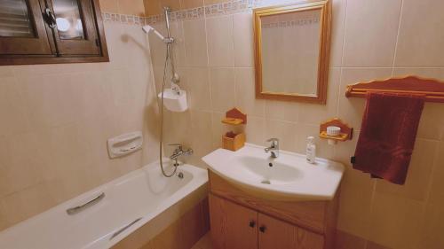 La salle de bains est pourvue d'un lavabo, d'un miroir et d'une baignoire. dans l'établissement STAY Forest View Villa, à Plátres