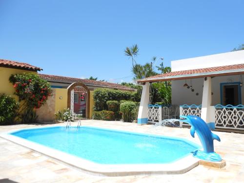 a swimming pool with a blue dolphin in a yard at Pousada Jesmar in Praia do Frances