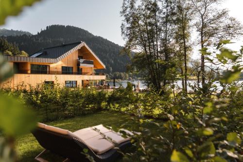 uma rede em frente a uma casa com um lago em Alpenhotel Kitzbühel am Schwarzsee - 4 Sterne Superior em Kitzbühel