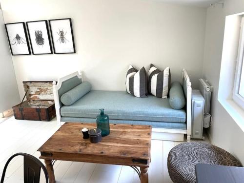 salon z kanapą i drewnianym stołem w obiekcie Cosy Camon Bolt-Hole w mieście Camon