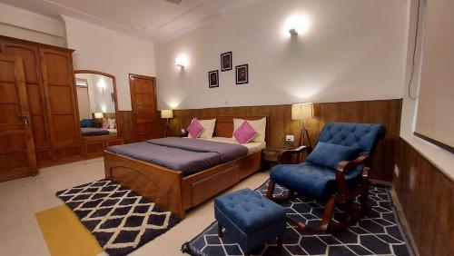 a bedroom with a bed and a chair in a room at Luxury Cottage by iTvara in Rishīkesh