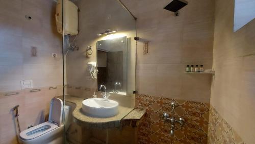 a bathroom with a sink and a shower and a toilet at Luxury Cottage by iTvara in Rishīkesh
