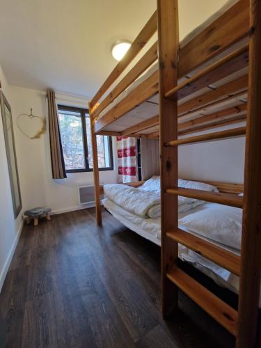 two bunk beds in a room with wooden floors at Boost Your Immo Vars Ô Chalet Dana 801 in Vars