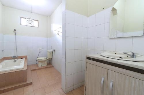 uma casa de banho com um lavatório, uma banheira e um WC. em Kampung Pa'go Resort Hotel em Bandung
