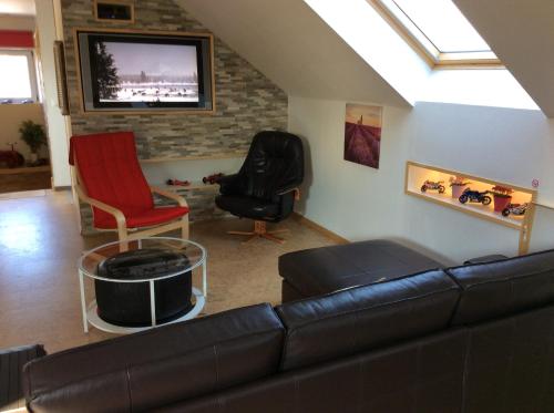 a living room with a couch and two chairs and a tv at Éco Gîtes Aubelrando & villa-bocage in Aubel