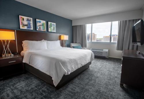 スーフォールズにあるHoliday Inn Sioux Falls-City Center, an IHG Hotelのベッドと大きな窓が備わるホテルルームです。