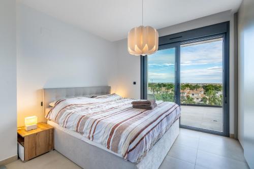 a bedroom with a bed and a large window at Apartamento Verano in Orihuela