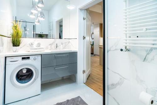 een badkamer met een wasmachine en een douche bij ApartamentySnu, Struga Tower Double Gold z parkingiem in Radom