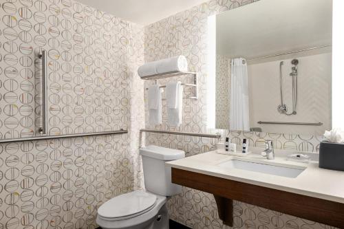 a bathroom with a white toilet and a sink at Holiday Inn Orlando International Airport by IHG in Orlando