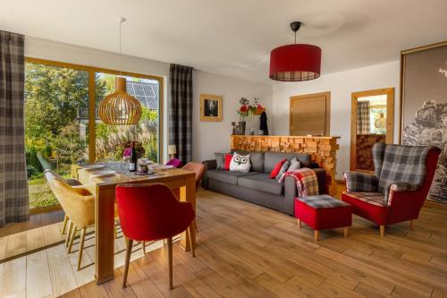 a living room with a couch and a table at Apartamenty u Harrego II Przy Stawie Spa klimatyzacja,balkon,sauna , balia, ogród,parking in Kudowa-Zdrój