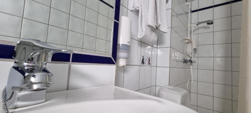 a white bathroom with a sink and a shower at Storstua omsorgs- og konferansesenter in Røyken