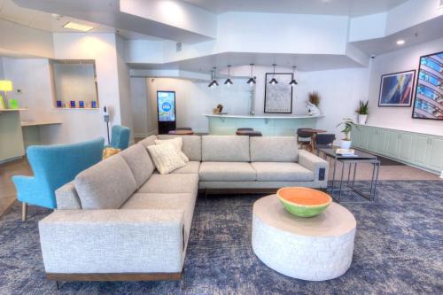a living room with a couch and a table at Holiday Inn Gainesville-University Center by IHG in Gainesville