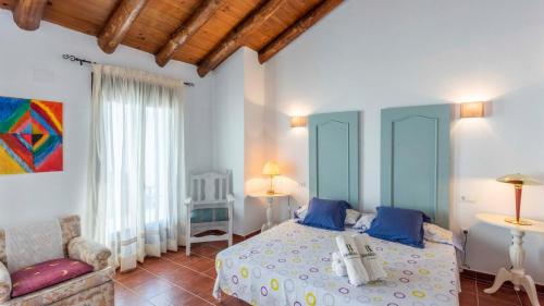 a bedroom with a bed and a couch at La Fresneda Cortes de la Frontera by Ruralidays in Cañada del Real Tesoro