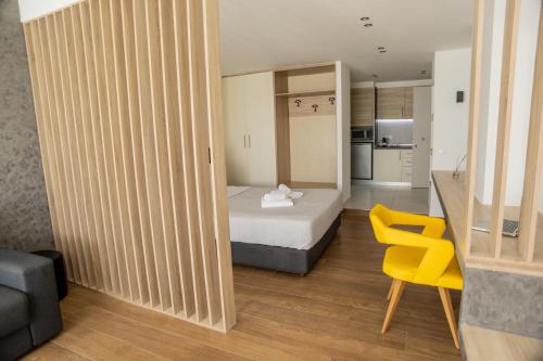 Cette petite chambre comprend un lit et une chaise jaune. dans l'établissement VH Executive Suites, à Thessalonique