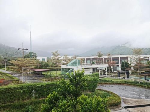 a group of buildings in a park with trees and bushes at The Midst by The M - Nakhon Nayok TMD4 in Ban Som Phung Haeng (1)