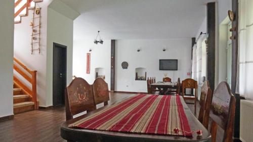 a living room with a table and a rug on the floor at Sura Pietrei Craiului in Zărneşti