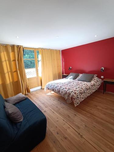 une chambre avec deux lits et un mur rouge dans l'établissement Grand Gîte terrasses Largentière, à Largentière