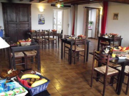 een eetkamer met tafels en stoelen en fruit op tafels bij La Roche du Marais in Omonville-la-Petite