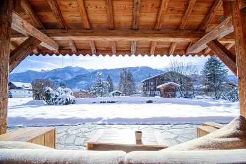 a living room with a view of a snow covered yard at Residence Hôtelière La Renardiere in Samoëns