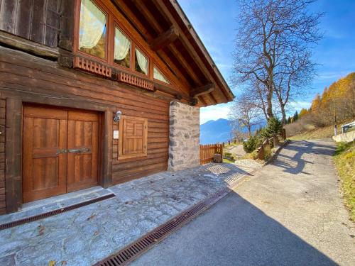 a house with a wooden door and a driveway at Monolocale in chalet alpino 022143-AT-010681 in Madonna di Campiglio