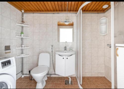 a bathroom with a toilet and a sink at Easy and short from the airport in Helsinki