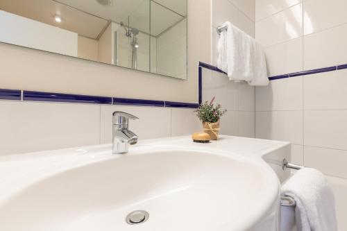 a white bathroom with a sink and a mirror at Select Hotel Rüsselsheim in Rüsselsheim