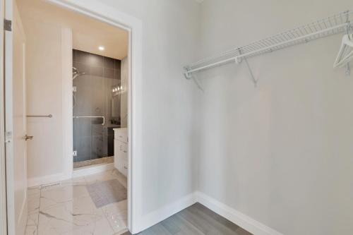 a white bathroom with a walk in shower and a mirror at GLOBALSTAY New 16 Ppl Townhouses in Windsor Hot Tub & Sauna in Windsor