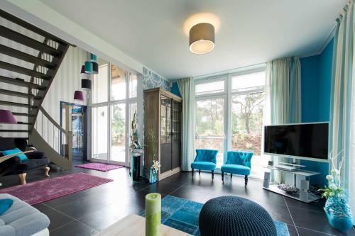 a living room with blue walls and a tv at Kapitaensweg 24 in Ostseebad Karlshagen