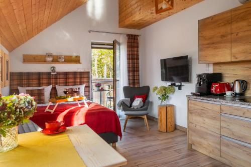 a bedroom with a bed with a red bedspread at Apartamenty u Harrego II Przy Stawie Spa klimatyzacja,balkon,sauna , balia, ogród,parking in Kudowa-Zdrój